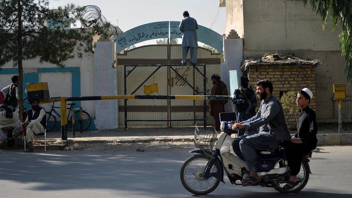 A Taliban replaces a sign of the Department for Women's Affairs with the Ministry for the Promotion of Virtue and Prevention of Vice, at an entrance gate of a government building in Kandahar on October 20, 2021. (AFP)