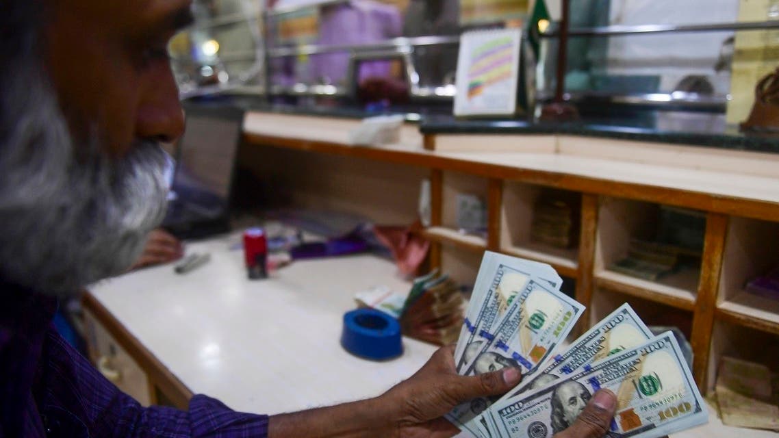 A foreign currency dealer counts US dollars at a shop in Karachi on May 19, 2022. (AFP)