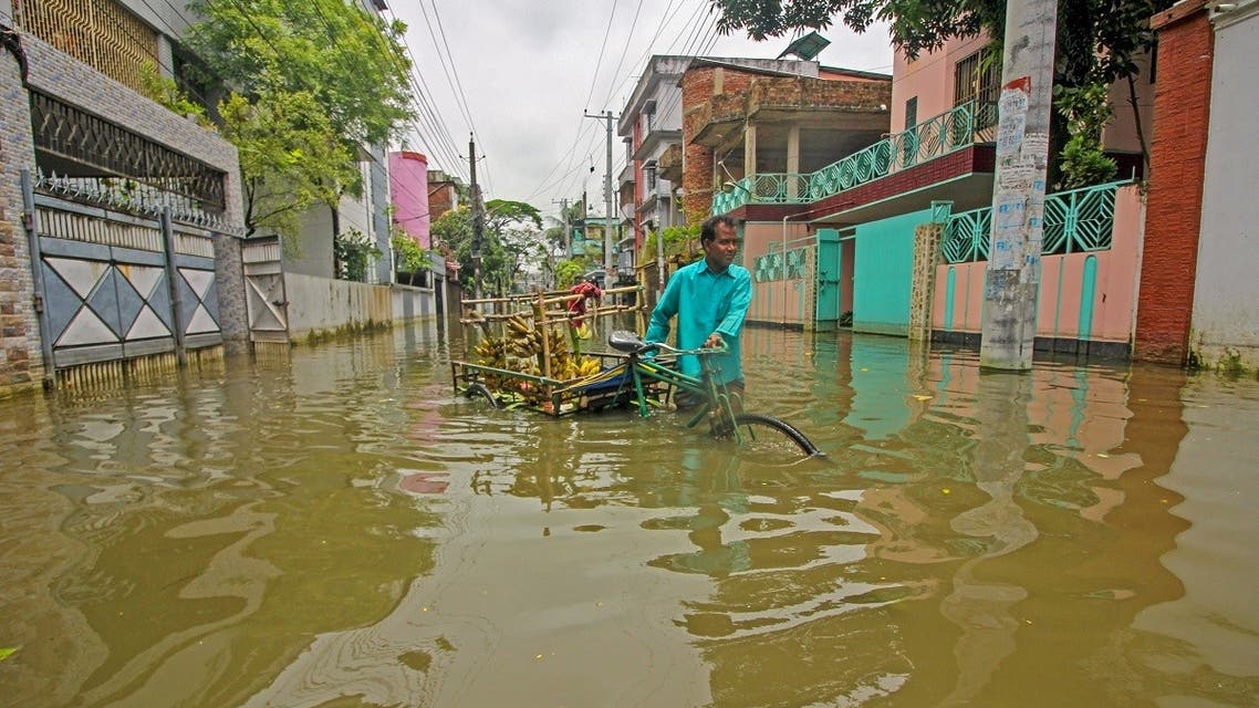 A fruit vendor sells bananas along a flooded street following heavy rains in Sylhet on May 21, 2022. (AFP)