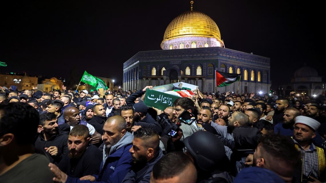 Palestinian mourners carry the body of Walid al-Sharif, 23, who died of wounds suffered last month during clashes with Israeli police at Jerusalem's flashpoint al-Aqsa mosque compound, on May 16, 2022 in front of the Dome of the Rock mosque at the al-Aqsa compound. (AFP)