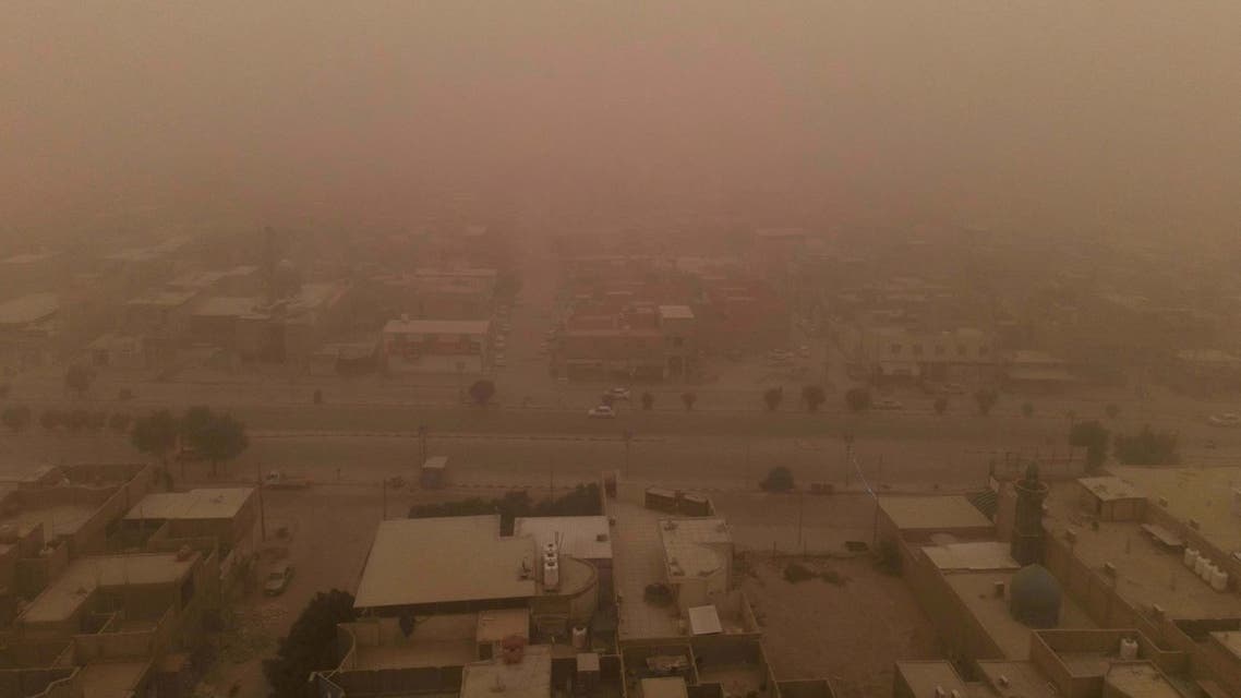 An aerial picture shows a blanket of dust engulfing Iraq's central holy city of Najaf, on May 23, 2022. Iraq closed airports and public buildings as a dust storm -- the ninth since mid-April -- hit the country, authorities said. (Photo by Ali NAJAFI / AFP)