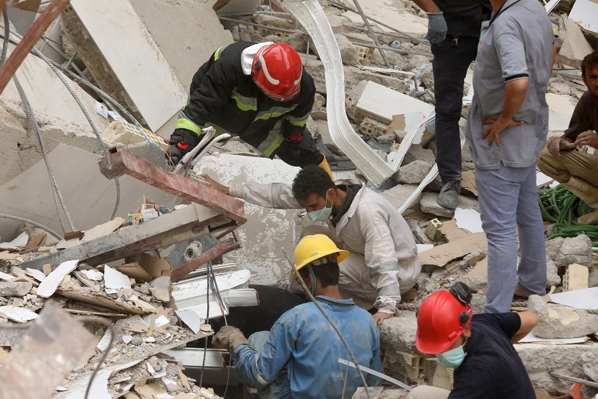 Iranians rescuers scour the rubble at the site where a ten-storey building collapsed, as rescue operations continue in the southwestern city of Abadan on May 24, 2022. (AFP)