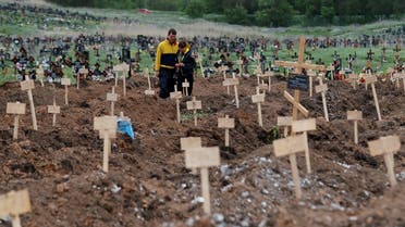 People stand amid newly-made graves at a cemetery in the course of Ukraine-Russia conflict in the settlement of Staryi Krym outside Mariupol, Ukraine on May 22, 2022. (Reuters)