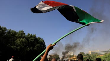 A Sudan flag is being flown as protesters march during a rally against the military rule, following last month's coup in Khartoum, Sudan, January 9, 2022. REUTERS/Mohamed Nureldin Abdallah