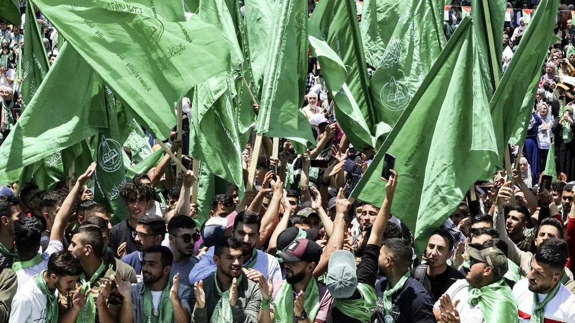 Palestinian students supporting the Hamas movement wave the movement's flag as they celebrate a victory in student elections at Birzeit University on the outskirts of Ramallah in the occupied West Bank on May 19, 2022. (AFP)
