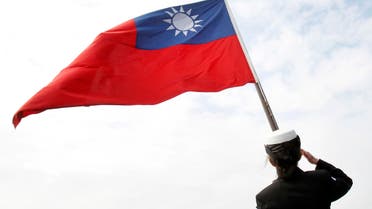 FILE - In this Jan. 31, 2018, file photo, a Taiwanese military officer salutes to Taiwan's flag onboard Navy's 124th fleet Lafayette frigate during military exercises off Kaohsiung, southern of Taiwan. China and Taiwan traded accusations Monday, Oct. 19, 2020, over a violent altercation that broke out between Chinese diplomats and Taiwan government employees at a recent Taiwan National Day reception in Fiji. (AP Photo/Chiang Ying-ying, File)