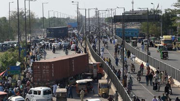 Commuters try to make their along a road partially blocked with containers by local authorities to hinder mobility ahead of the sit-in planned in Islamabad by Pakistan Tehreek-e-Insaf (PTI) party's former Pakistan's Prime Minister Imran Khan, in Lahore on May 24, 2022. (AFP)