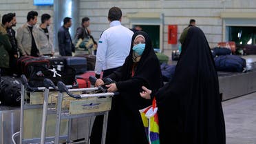 Women arriving from Iran wearing masks in Najaf, Iraq, Friday, Feb. 21, 2020. Iraqi authorities are taking precautions at Najaf and other Iraqi airports, as well as at the border gates with Iran, after the discovery of the new virus that emerged in China in Iran. (AP Photo/Anmar Khalil)