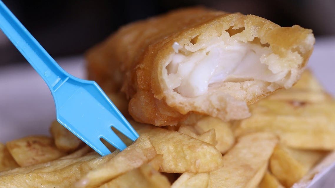 A plastic fork stands in a portion of fish and chips from a fish and chip shop is pictured in Manchester, Britain, on May 18, 2022. (Reuters)