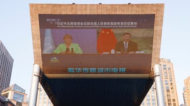 Chinese President Xi Jinping and United Nations High Commissioner for Human Rights Michelle Bachelet are seen on a giant screen broadcasting news footage of their virtual meeting at a shopping complex in Beijing, China on May 25, 2022. (Reuters)