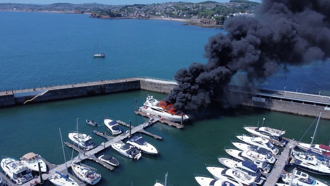 Thick black smoke rises from a fire on a yacht, at Torquay harbour in Torquay, Britain May 28, 2022. (Mike Trower/Handout via Reuters)