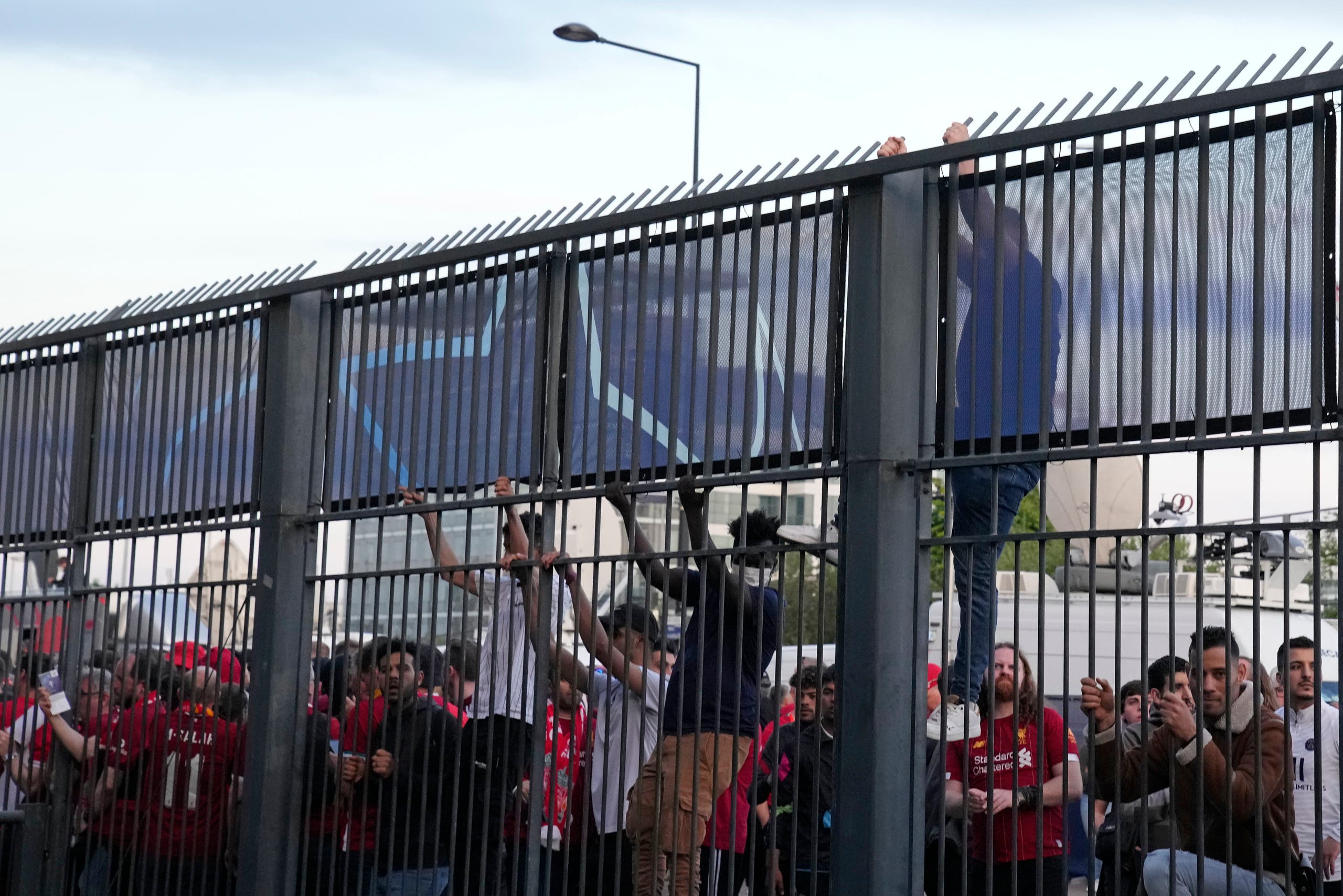 مشجعون يحاولون تسلق السياج للدخول للملعب