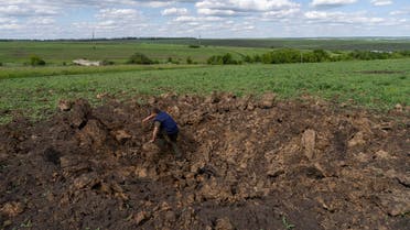 A farm worker climbs out of a crater caused by shelling in a field in Cherkaska Lozova, outskirts of Kharkiv, eastern Ukraine, Saturday, May 28, 2022. Ukraine is one of the world's largest exporters of wheat, corn and sunflower oil, but the war and a Russian blockade of its ports have halted much of that flow, endangering world food supplies. Many of those ports are now also heavily mined. (AP Photo/Bernat Armangue)