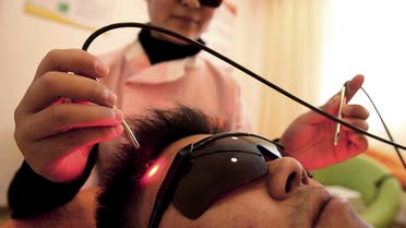 A person receives laser treatment to help him stop smoking at a healing centre in Nanjing in east China's Jiangsu province in this October 24, 2006 picture. CHINA OUT REUTERS/China Daily (CHINA)
