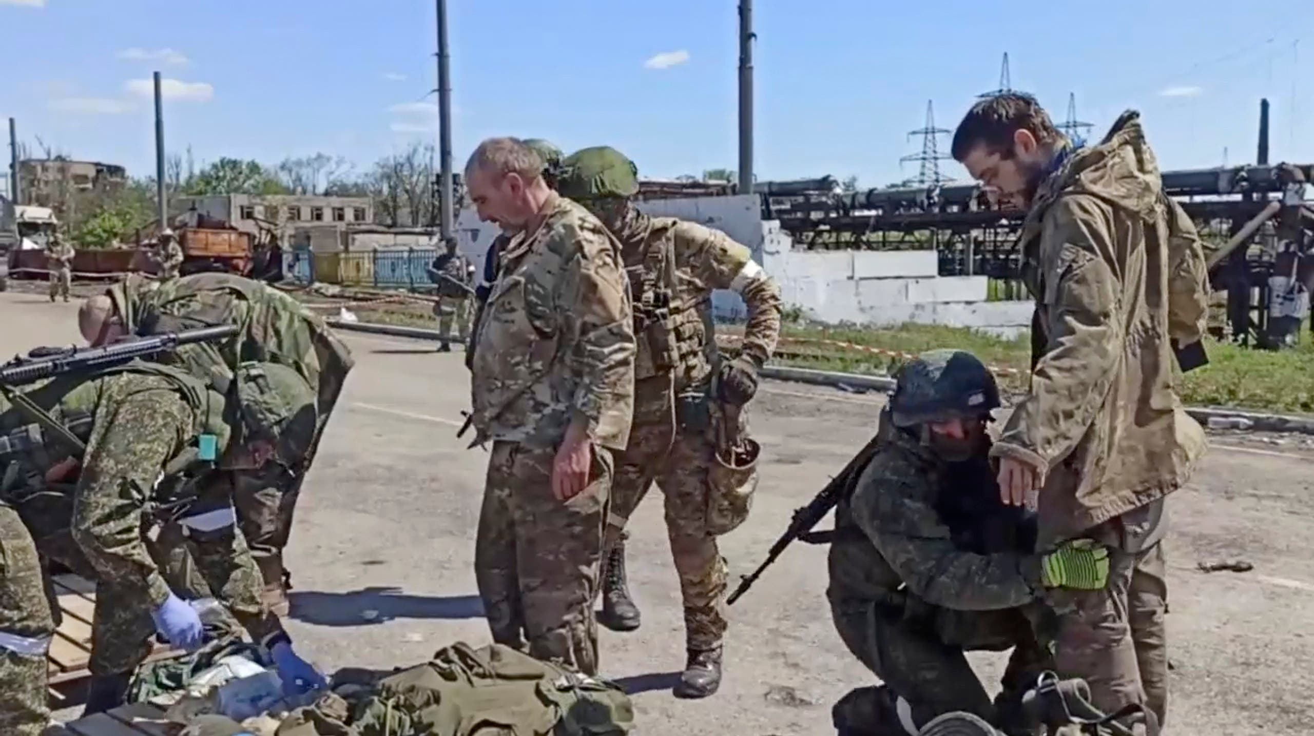 جنود روس يفتشون مقاتلي آزوفستال بعد استسلامهم