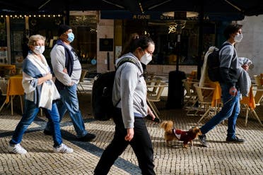 People wearing protective masks walk in Lisbon, Portugal, December 21, 2021. (File photo: Reuters)