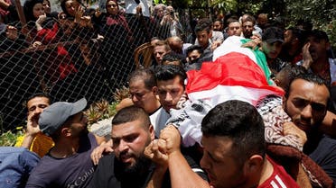 Mourners carry the body of a Palestinian woman, who was killed in an incident at an Israeli checkpoint, during her funeral in al-Arroub refugee camp near Hebron in the Israeli-occupied West Bank, on June 1, 2022. (Reuters)
