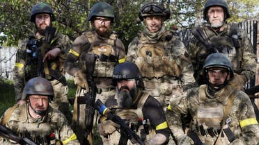 Commander Vsevolod Kozhemyako poses with his soldiers in Ruska Lozova, a village retaken by the Ukrainian forces from Russia, in Kharkiv, May 16, 2022. (Reuters)