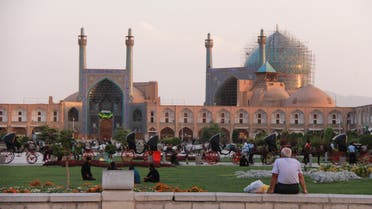 Tourists sit outside the Lotfallah Mosque at the historical Naqsh-e Jahan Square in the central Iranian city of Isfahan on September 24, 2018. / AFP / Sarah LAI
