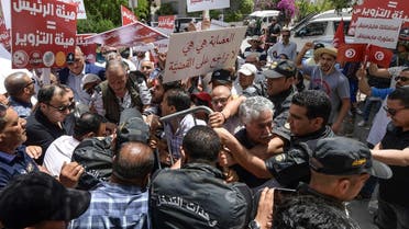 Tunisian labour party spokesman Hamma Hammami (C) is among demonstrators blocked by the police as they headed toward the headquarters of the electoral authority ISIE, during a rally against their president, in the capital Tunis, on June 4, 2022. (AFP)
