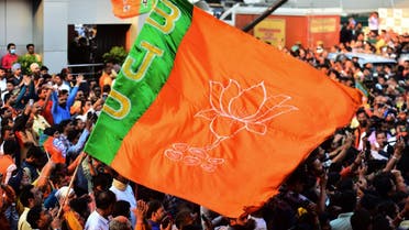 In this picture taken on March 10, 2022, supporters of India's Bharatiya Janata Party (BJP) wave their flag as they celebrate party's win in Uttar Pradesh state assembly elections outside the party office in Lucknow. (AFP)