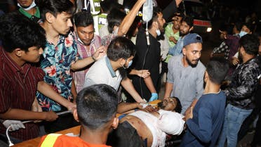Rescue workers and civilians carry an injured victim to a hospital in Chittagong, after a fire broke out at a container storage facility in Chittagong, on June 5, 2022. (AFP)