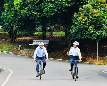 Indonesian President Joko Widodo talks with Australian Prime Minister Anthony Albanese as they ride bicycles during their meeting in Bogor, Indonesia, on June 6, 2022. (Reuters)