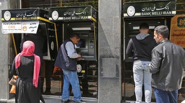 Iranians withdraw money from an ATM machine at a Bank Melli Iran branch in the capital Tehran, on April 24, 2019. Iranians, already hard hit by punishing US economic sanctions, are bracing for more pain after Washington abolished waivers for some countries which had allowed them to buy oil from Iran. / AFP / ATTA KENARE