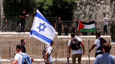 Israelis stand with an Israeli flag opposite to Palestinians with Palestinian flag next to Damascus gate to Jerusalem's Old City May 29, 2022. (File photo: Reuters)