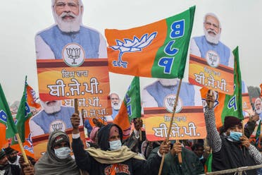 Bharatiya Janata Party (BJP) supporters hold BJP party flags and cut-outs with portrait of BJP leader and India's Prime Minister Narendra Modi during a rally ahead of the state assembly elections in Ferozepur on January 5, 2022 which was reportedly cancelled later citing security concerns. (AFP)