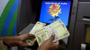 A man counts money after withdrawing it from a State Bank of India automated teller machine (ATM) in Mumbai, India. (Reuters)