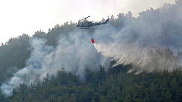 A firefighting helicopter drops water on the Batramaz forest fire in Lebanon’s northern district of Minie-Danniye, on June 8, 2022. (AFP)