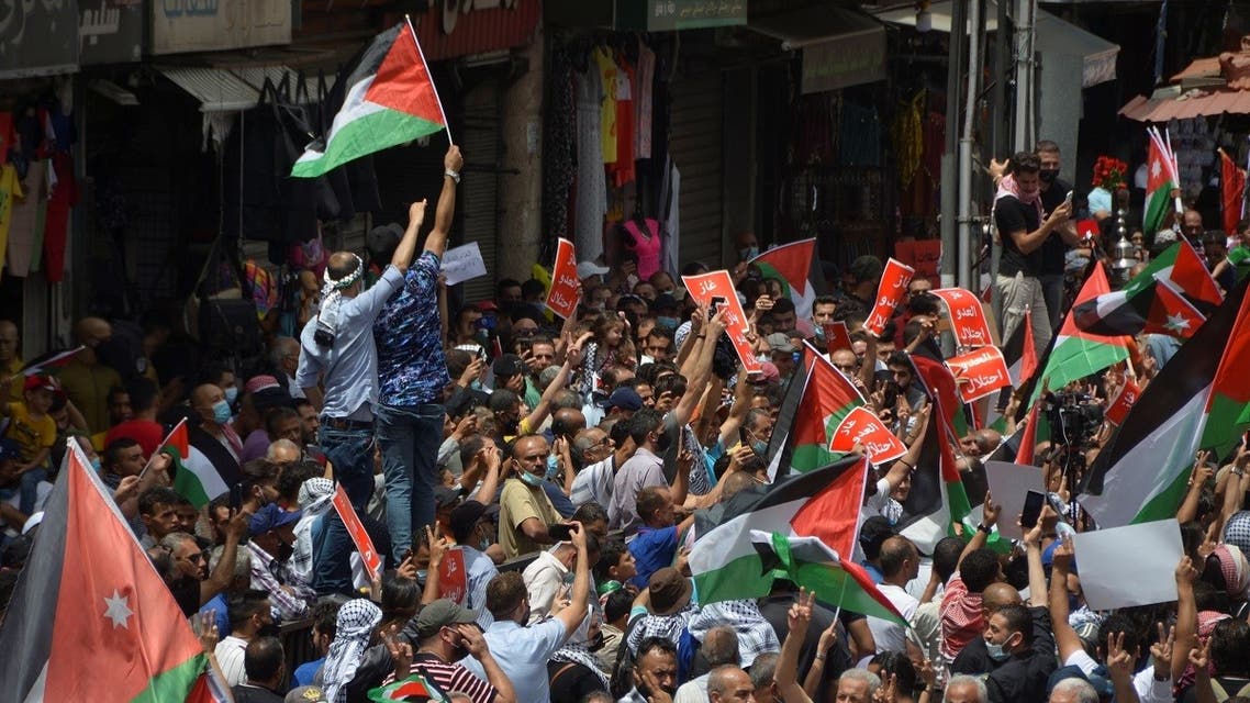 Jordanians carry flags and banners during a demonstration to express solidarity with the Palestinian people and to celebrate the Israel-Hamas truce, in Amman, Jordan, May 21, 2021. (Reuters)