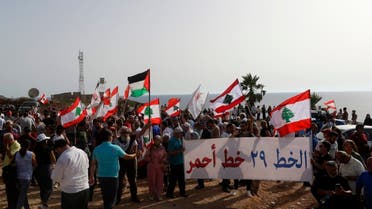 Lebanese protesters take part in a demonstration at the Lebanese southernmost border area of Naqura, on June 11, 2022, days after Israel moved a gas production vessel into an offshore field, a part of which is claimed by Lebanon. (AFP)