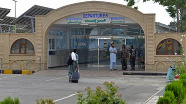A passenger with his belongings walks towards the entrance gate of the airport in Kabul on June 12, 2022. (AFP)