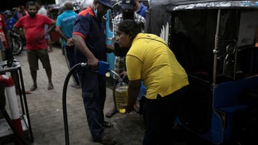 An auto-rickshaw driver for local ride hailing app PickMe has a container filled with petrol during the early hours of the morning at a fuel station in Gonapola town, on the outskirts of Colombo, Sri Lanka, May 26, 2022. (File photo: Reuters)