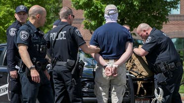A police officer holds one of a group of men, among 31 arrested for conspiracy to riot and affiliated with the white nationalist group Patriot Front, after they were found in the rear of a U Haul van in the vicinity of a North Idaho Pride Alliance LGBTQ+ event in Coeur d'Alene, Idaho, U.S. June 11, 2022. REUTERS/John Rudoff TPX IMAGES OF THE DAY