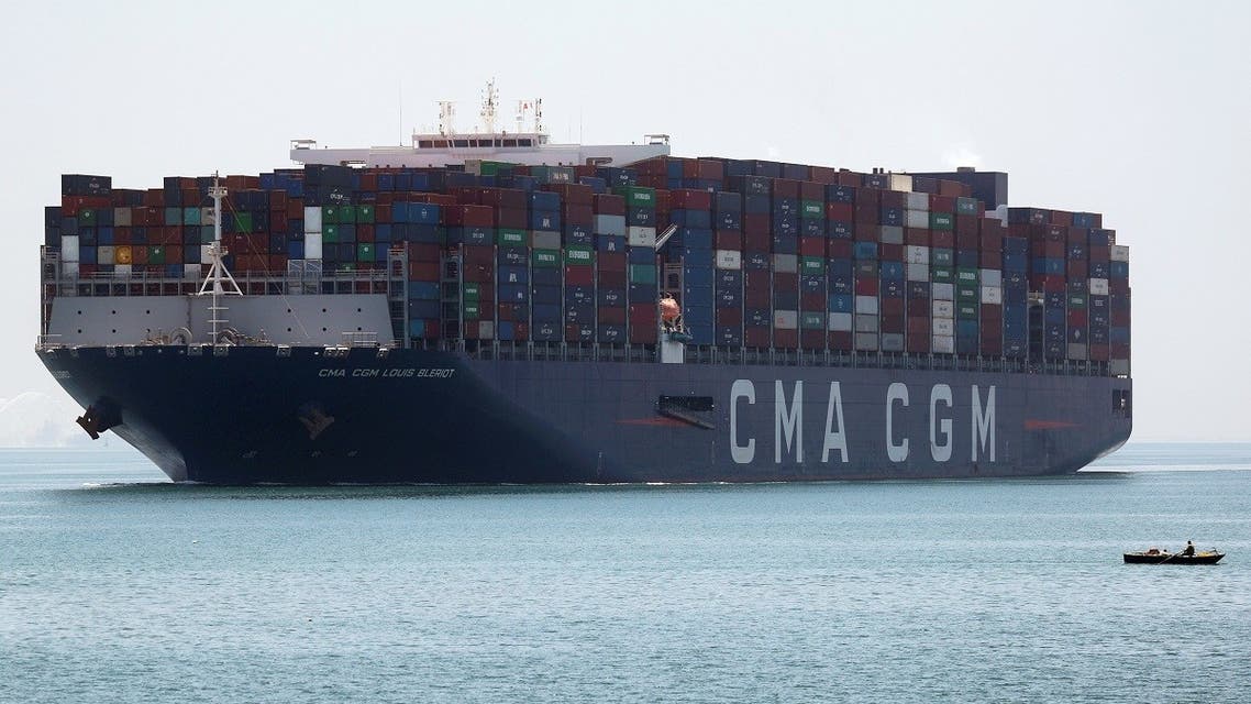 A fisherman travels on a boat in front of a CMA CGM container ship passing through the Suez Canal in Ismailia, Egypt. (Reuters)