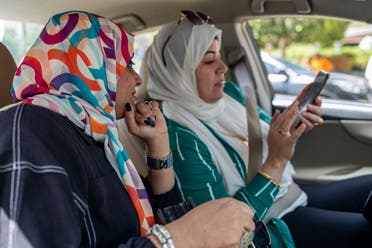 Shima Fikry shows one of her customers the itinerary for a trip and photos from travels she had organized over the years. Since April 2021, she has organized over 30 one-day trips to cities across Egypt. (Photo: Toka Omar)