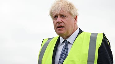 British Prime Minister Boris Johnson looks on as he works with seasonal workers (not pictured) to pick courgettes during a visit to Southern England Farms Ltd in Hayle, Britain June 13, 2022. (Reuters)
