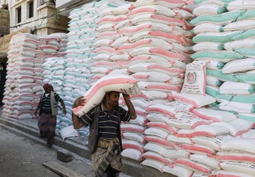 A worker carries a sack of wheat flour outside a store in Sanaa, Yemen May 17, 2022. Picture taken May 17, 2022. (Reuters)