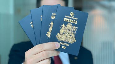 Stock image of a man holding a Grenada passport. (Supplied)