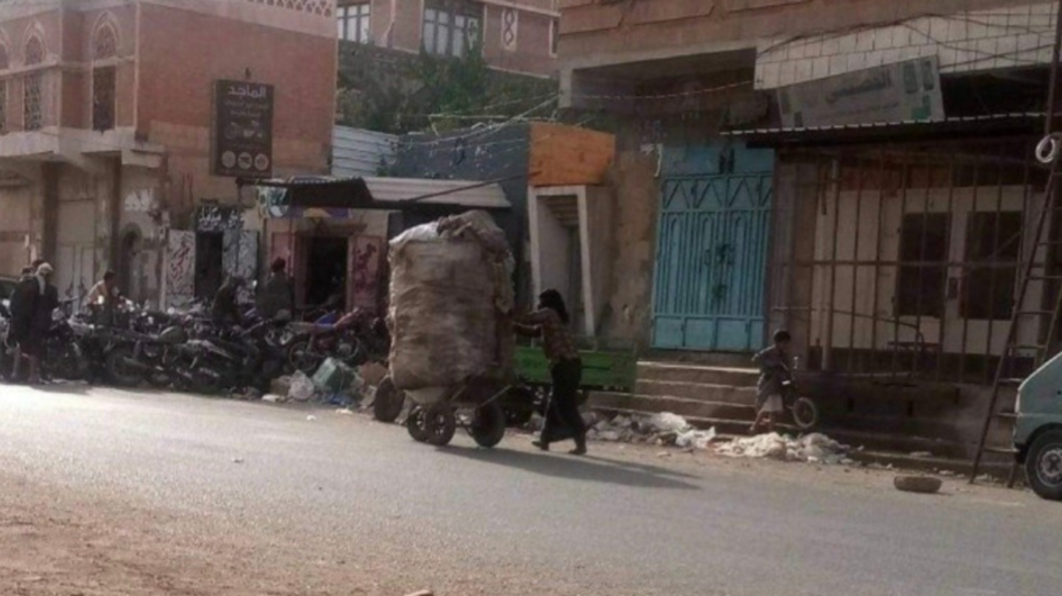 كل القهر بصورة.. زوجة صحافي يمني تلم النفايات بصنعاء