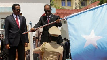 Somalia's newly elected President Hassan Sheikh Mohamud holds their national flag from outgoing President Mohamed Abdullahi Mohamed at the handover ceremony at the palace in Mogadishu, Somalia May 23, 2022. (Reuters)