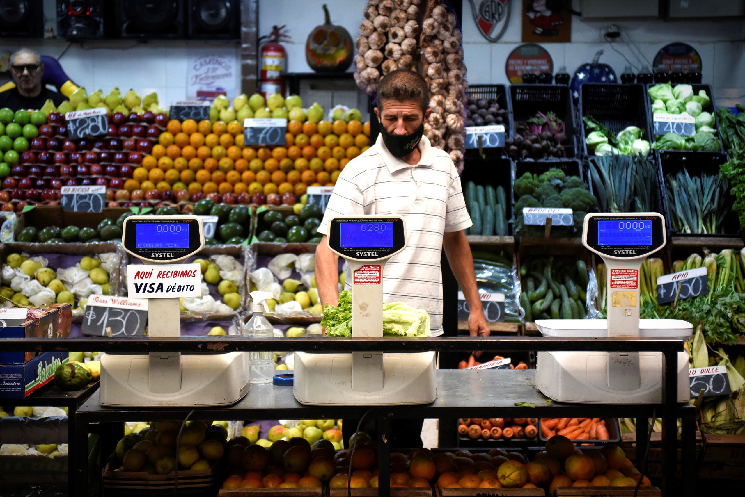 A vendor weighs produce in a market as inflation in Argentina hits its highest level in years, causing food prices to spiral, in Buenos Aires, Argentina April 12, 2022. Picture taken April 12, 2022. (Reuters)