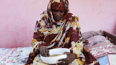 Magda Ahmed, Sudanese mother of orphan children who applied for Sudan’s Thamarat Family Support Programme, holds a bowl of food in South Khartoum April 26, 2021. Picture taken April 26, 2021. REUTERS/El-Tayeb Siddig