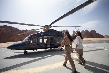 View shows two people walking towards a helicopter for a 30 minute tour of Al Ula, Saudi Arabia. (Supplied)