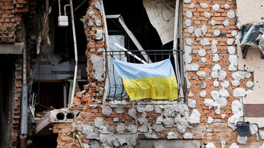 A Ukrainian national flag hangs from a balcony of a destroyed civilian building in Irpin, Ukraine June 16, 2022. Ludovic Marin/Pool via REUTERS