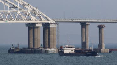 FILE PHOTO: A vessel sails past a bridge connecting the Russian mainland with the Crimean Peninsula across the Kerch Strait, Crimea November 26, 2018. REUTERS/Pavel Rebrov/File Photo