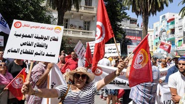 Supporters of the Tunisian General Labor Union (UGTT) gather with national flags during a rally outside its headquarters in the capital Tunis on June 16, 2022, amid a general strike announced by the UGTT. (AFP)